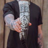 Man holding Viking Life drinking horn upright, showing the carved triquetra and knotwork